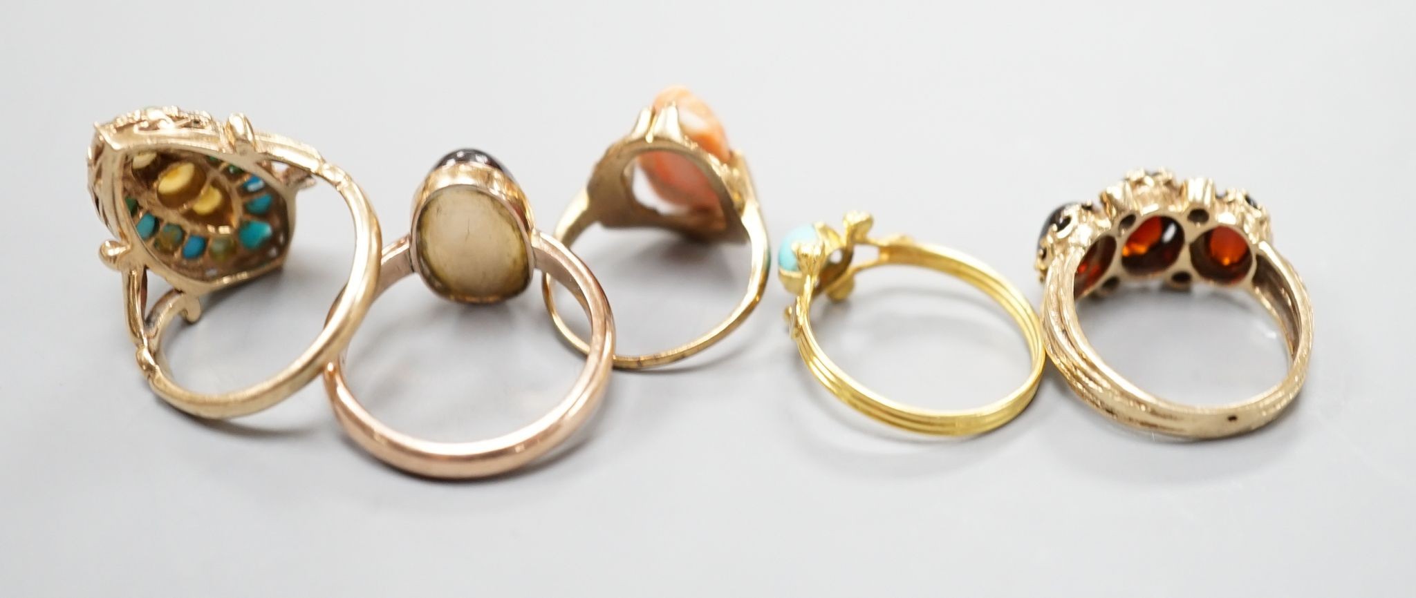 Three assorted modern 9ct gold and gem set ring including turquoise and seed pearl, gross 11.2 grams, a 10k and coral set ring, gross 2.7 grams and a yellow metal and turquoise set ring, gross 1.3 grams.